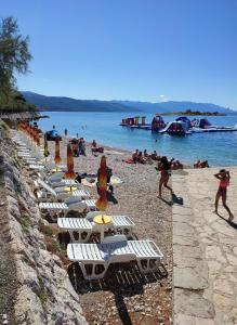 a row of chairs and umbrellas on a beach at Double Room Novi Vinodolski 2350a in Novi Vinodolski +9 photos