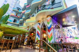 un edificio con una fachada colorida con mesas y sillas en Boutique Hotel La Villa, en Nha Trang