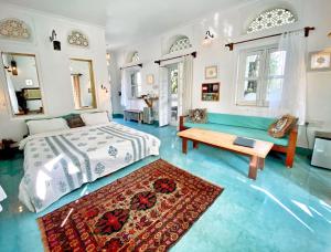 - une chambre avec un lit, un banc et une table dans l'établissement Dia Homestay, à Pushkar