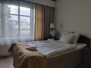 a bedroom with a large bed with a window at Hotelli Patruuna in Imatra