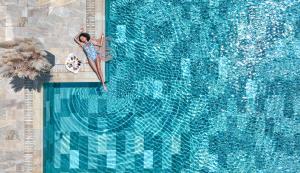 an overhead view of a person swimming in a swimming pool at HVD Reina del Mar - Premium Spa Service & Free Parking in Obzor