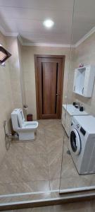 Un baño con inodoro y lavadora. en ELEANA, en Borjomi