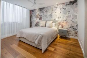 1 dormitorio con 1 cama y un mural en la pared en Penthouse On The Promenade, en Batemans Bay