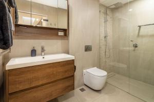 a bathroom with a toilet and a sink and a shower at Penthouse On The Promenade in Batemans Bay