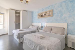 2 łóżka w pokoju z niebieskimi ścianami w obiekcie Penthouse Apartment on Los locos B w mieście Torrevieja