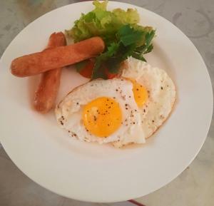 un plato con dos huevos fritos, zanahorias y verduras en Blue Lagoon, en Baie Lazare Mahé