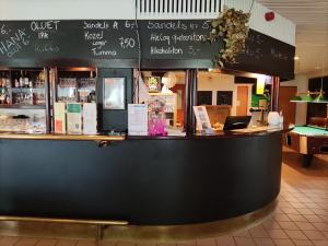 a restaurant with a black counter with a bar at Hotelli Patruuna in Imatra +7 photos
