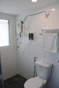 a white bathroom with a toilet and a shower at Happy Valley Eco Farm in Kerling