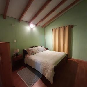 um quarto com uma cama e uma janela em Cabañas El Portal em Neltume