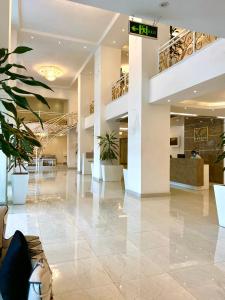 a lobby of a building with plants and stairs at De Leopol Hotel in Addis Ababa