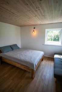 um quarto com uma cama e uma janela em Arčiau Gamtos Virinta em Kurkliai