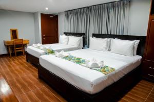 two beds in a hotel room with towels on them at One Averee Bay Hotel in Coron