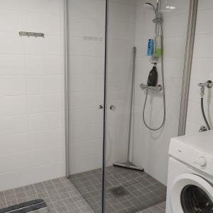 a bathroom with a shower and a washing machine at Lovely new city apartment all amenities in Seinäjoki