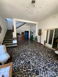 a living room with a stone floor and a chandelier at Hotel Naviglio in Marina di Pietrasanta