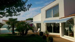 a house with a porch and a patio at Chambre d'Hôtes Armoise in Lagord