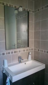 y baño con lavabo blanco y espejo. en Chambre d'Hôtes Armoise, en Lagord