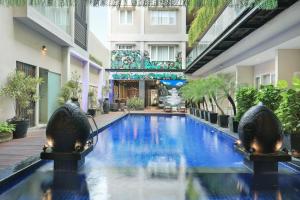 a swimming pool in the middle of a building at Ohana Hotel Kuta in Kuta