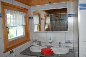 a bathroom with two sinks and a mirror at BnB-Blomberg in Ebnat