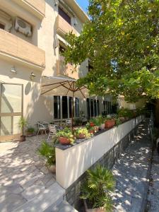 a retaining wall with potted plants and an umbrella at Hotel Naviglio in Marina di Pietrasanta