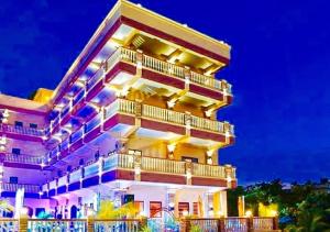 a building with balconies on it at night at RedDoorz @ Joyce Palace Antique in San Jose de Buenavista