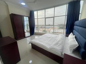 a bedroom with a bed and a large window at RED-25 - Razat Alard 4 in Salalah