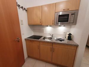 a small kitchen with a sink and a microwave at Ski-in cosy studio in Saas-Fee