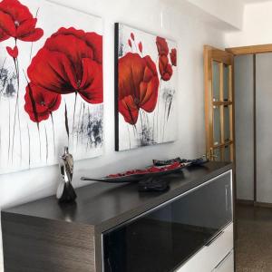 three red poppies paintings on a white wall at Apartament La Calita in Peniscola +16 photos