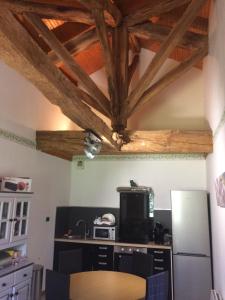 a kitchen with a wooden ceiling with wooden beams at La Grenouille in Saint-Adjutory +10 photos