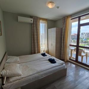 een slaapkamer met een bed en een groot raam bij Sorrento Sole Mare - Apartments by the beach in Sveti Vlas