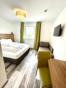 Habitación de hotel con cama y silla en Motel XL Lounge en Traisen