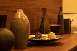 東京的住宿－First Cabin Haneda Terminal 1，一张桌子,上面有各种花瓶和一盘食物