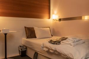 ein Schlafzimmer mit einem Bett mit Handtüchern darauf in der Unterkunft First Cabin Haneda Terminal 1 in Tokio