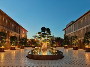 阿拉恰特的住宿－Biblos Resort Alaçatı，庭院里的一个大型喷泉,有树