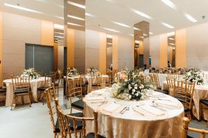 un salón de banquetes con mesas y sillas con flores en El Sancho Hotel, en Naga