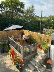 eine Terrasse mit einem Tisch, einem Sonnenschirm und Blumen in der Unterkunft Devonshire Terrace B&B in Truro