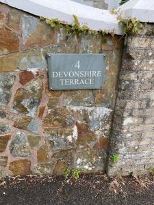 a sign on the side of a stone wall at Devonshire Terrace B&B in Truro