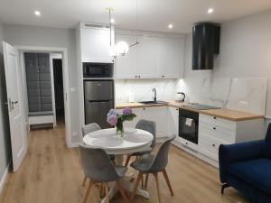 eine Küche und ein Esszimmer mit einem Tisch und Stühlen in der Unterkunft Apartament Margot - Centrum in Tarnów
