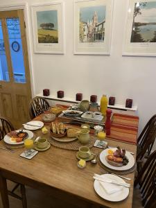 a wooden table with plates of food on it at Devonshire Terrace B&B in Truro