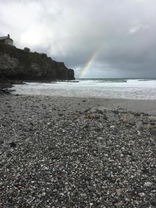 a rainbow on a beach with the ocean at Devonshire Terrace B&B in Truro