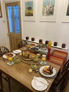 a wooden table with plates of food on it at Devonshire Terrace B&B in Truro