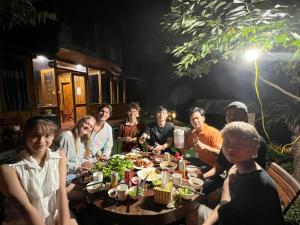 a group of people sitting around a table eating food at Sapa Eco Hugo in Sa Pa