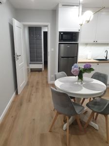 eine Küche und ein Esszimmer mit einem Tisch und Stühlen in der Unterkunft Apartament Margot - Centrum in Tarnów