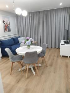 a living room with a table and chairs and a blue couch at Apartament Margot - Centrum in Tarnów
