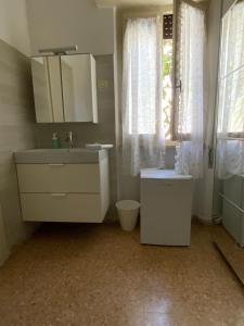 biała łazienka z umywalką i oknem w obiekcie Hotel Naviglio w mieście Marina di Pietrasanta
