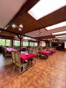 a dining room with pink tables and chairs at Chata Baryła in Sulęczyno