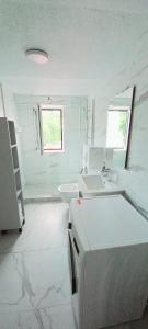 a white bathroom with a sink and a mirror at Apartments Ćemo in Sarajevo