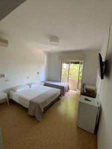 a bedroom with two beds and a window at Hotel Naviglio in Marina di Pietrasanta