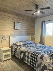 a bedroom with a bed and a ceiling fan at Ahmic Lake Resort in Magnetawan
