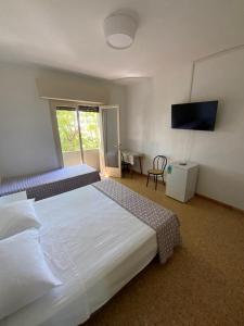 a hotel room with two beds and a television at Hotel Naviglio in Marina di Pietrasanta