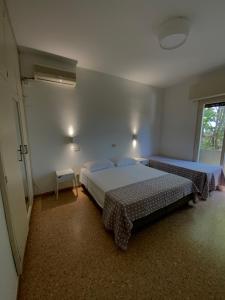 a bedroom with two beds and a window at Hotel Naviglio in Marina di Pietrasanta